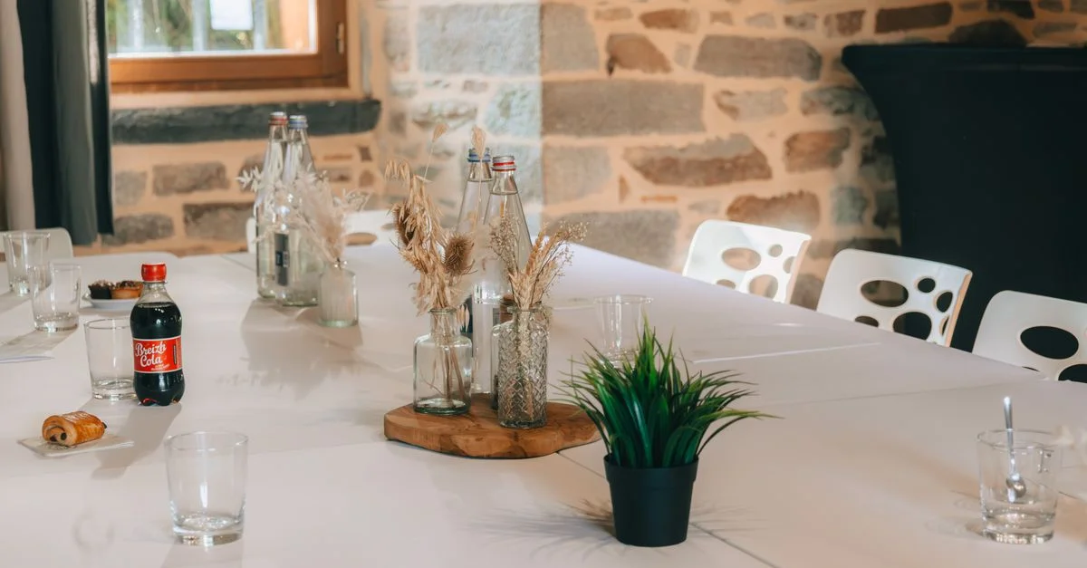 Une table de réunion intérieure moderne avec des rafraîchissements dans une salle confortable aux murs en pierre.