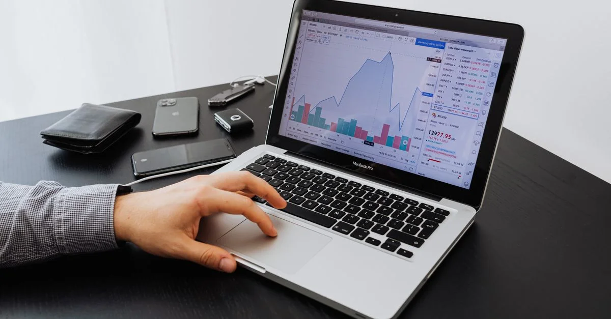 Personne analysant les données du marché boursier sur un ordinateur portable à un bureau.